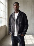 Black canvas chore jacket with patch pockets worn outdoors