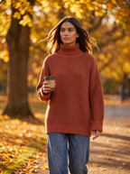 Model wearing brick red oversized turtleneck sweater outdoors in autumn