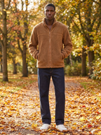 Camel brown sherpa fleece zip jacket with stand collar worn on an autumn park path