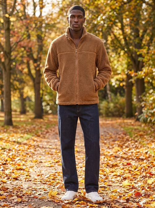 Camel brown sherpa fleece zip jacket with stand collar worn on an autumn park path