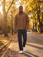 Model wearing camel sherpa fleece jacket on a tree lined street in autumn