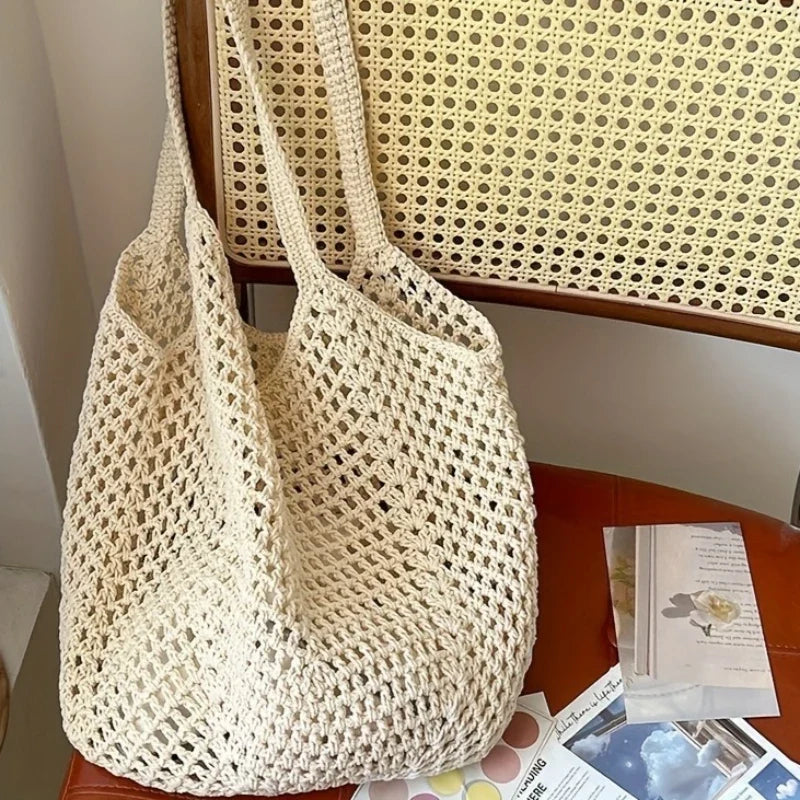 Crochet mesh tote bag held by the straps