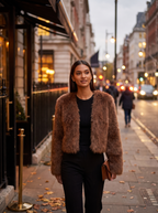 Cropped brown faux fur jacket styled for evening