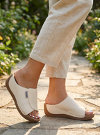 Woman wearing cushioned women's shoes with adjustable strap on a sunny garden path