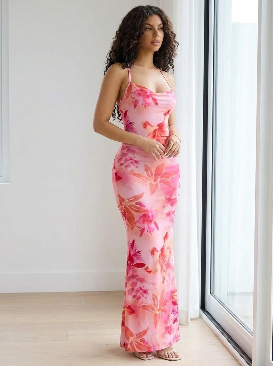 Woman wearing the pink floral knit maxi dress with draped neckline by a window