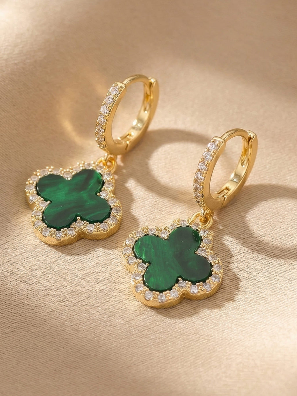 Gold-tone clover earrings worn, styled view