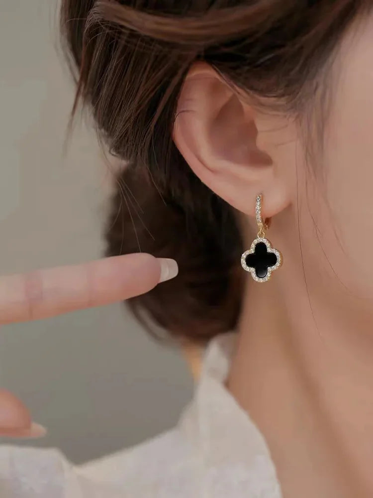 Gold-tone clover earrings, close-up detail