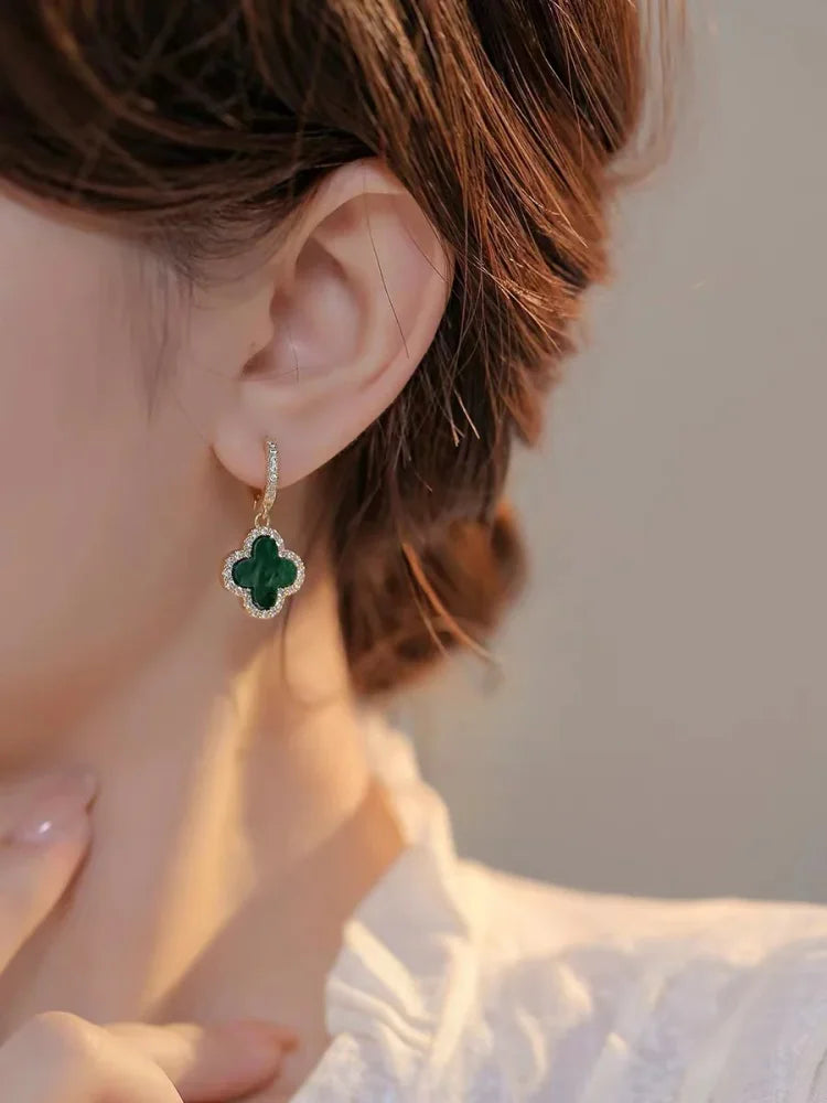 Gold-tone clover earrings, close-up detail