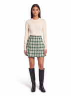 Green check pleated mini skirt worn by model, front view