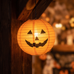 Close up of one lit paper pumpkin lantern