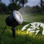 Close-up of the black projector light on its ground stake in grass