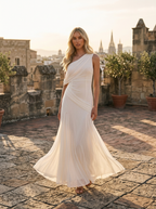 Woman wearing an oyster-white asymmetric one-shoulder draped maxi dress on a rooftop terrace
