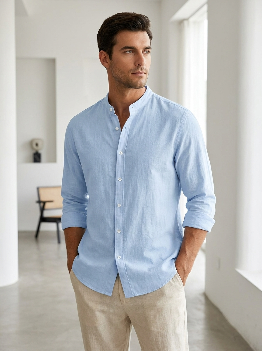 Man wearing a light blue band-collar long sleeve cotton button-up shirt in a modern interior