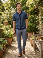 Man wearing a navy chevron knit short sleeve polo shirt on a garden patio