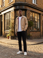 Beige harrington jacket with plaid lining worn on a brick street