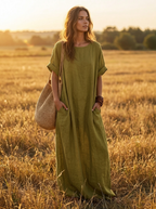 Olive green oversized linen-look boho maxi dress with pockets in an open field