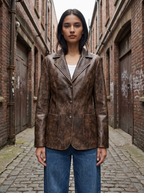 Woman wearing the distressed brown washed faux leather blazer in a brick alley