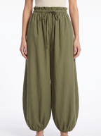 Close-up of the gathered high waistband and tapered leg