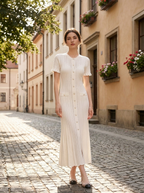 Model wearing a hollow-out knit button front maxi dress on a sunlit city street