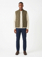 Olive quilted zip-up vest worn by model, front view