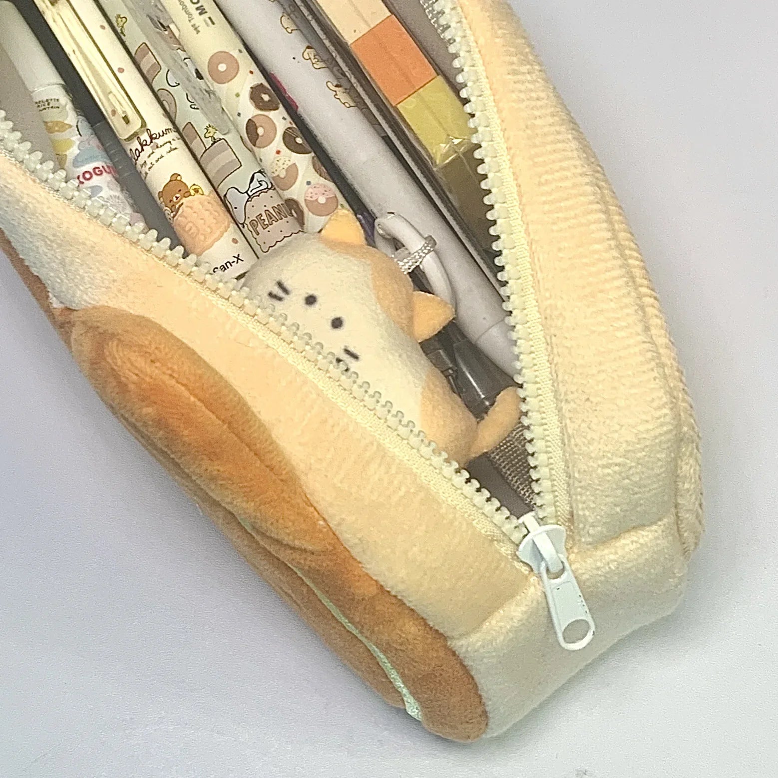 Plush pen case, held in hand for scale