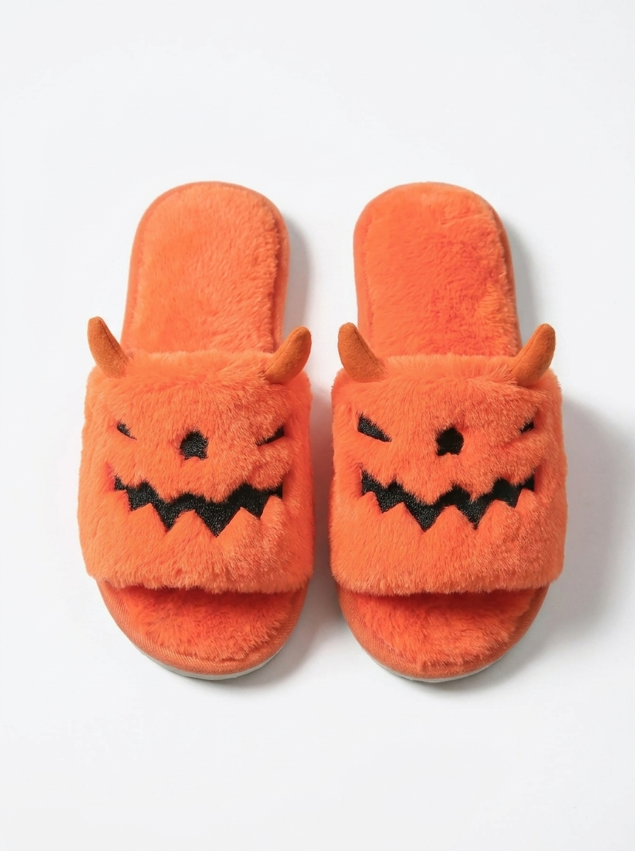 Pumpkin monster plush slippers on a white background