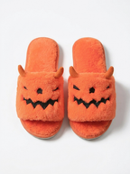 Pumpkin monster plush slippers on a white background