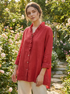 Woman wearing a ruffled collar long sleeve blouse in a sunlit garden