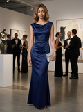 Woman wearing a navy satin cowl neck mermaid gown at an evening reception