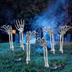 Skeleton hands rising from a graveyard lawn at night