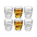 Clear skull-shaped shot glasses on a white background