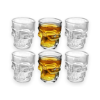 Clear skull-shaped shot glasses on a white background