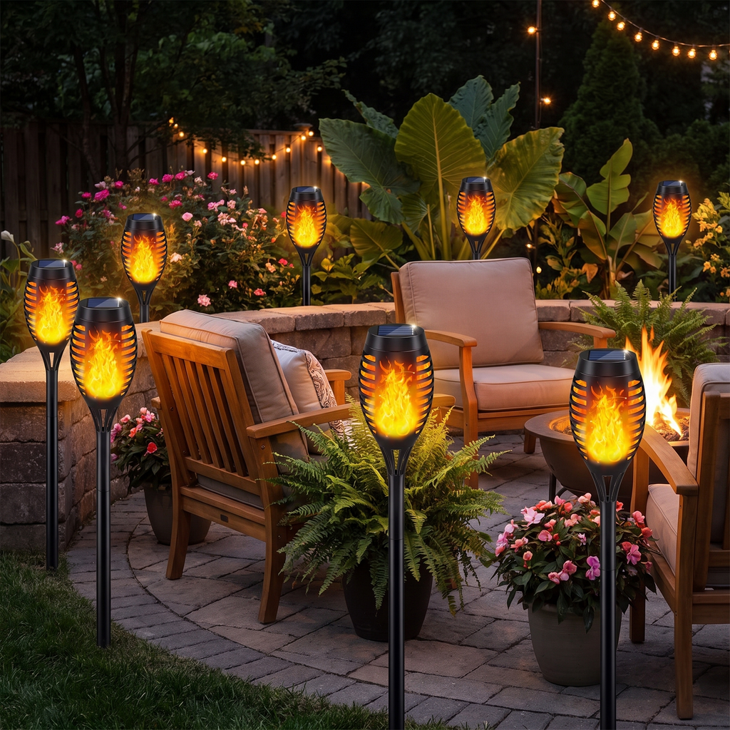 Solar flame torch lights around a backyard patio at night