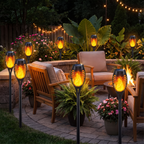 Solar flame torch lights around a backyard patio at night