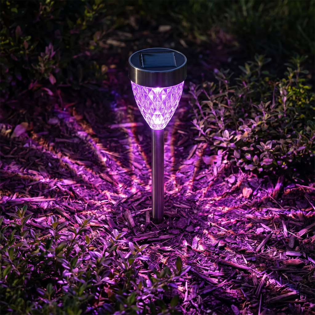 Close-up of a glowing purple diamond acrylic solar stake light in a garden bed
