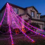 Giant light-up spider web stretched over a front yard at dusk