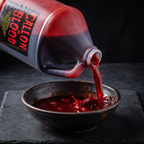 Gallon jug pouring thick red stage blood into a bowl