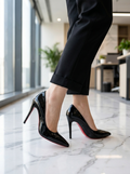 Pointed toe stiletto pumps worn on a polished floor