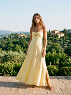 Strapless cotton maxi dress with twist front and side slit on a sunlit terrace