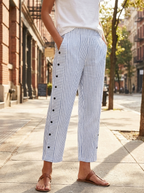 Striped tapered ankle pants with side pockets worn on a city street