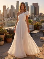 Woman wearing the white one shoulder dress with an A-line skirt on a rooftop terrace at golden hour