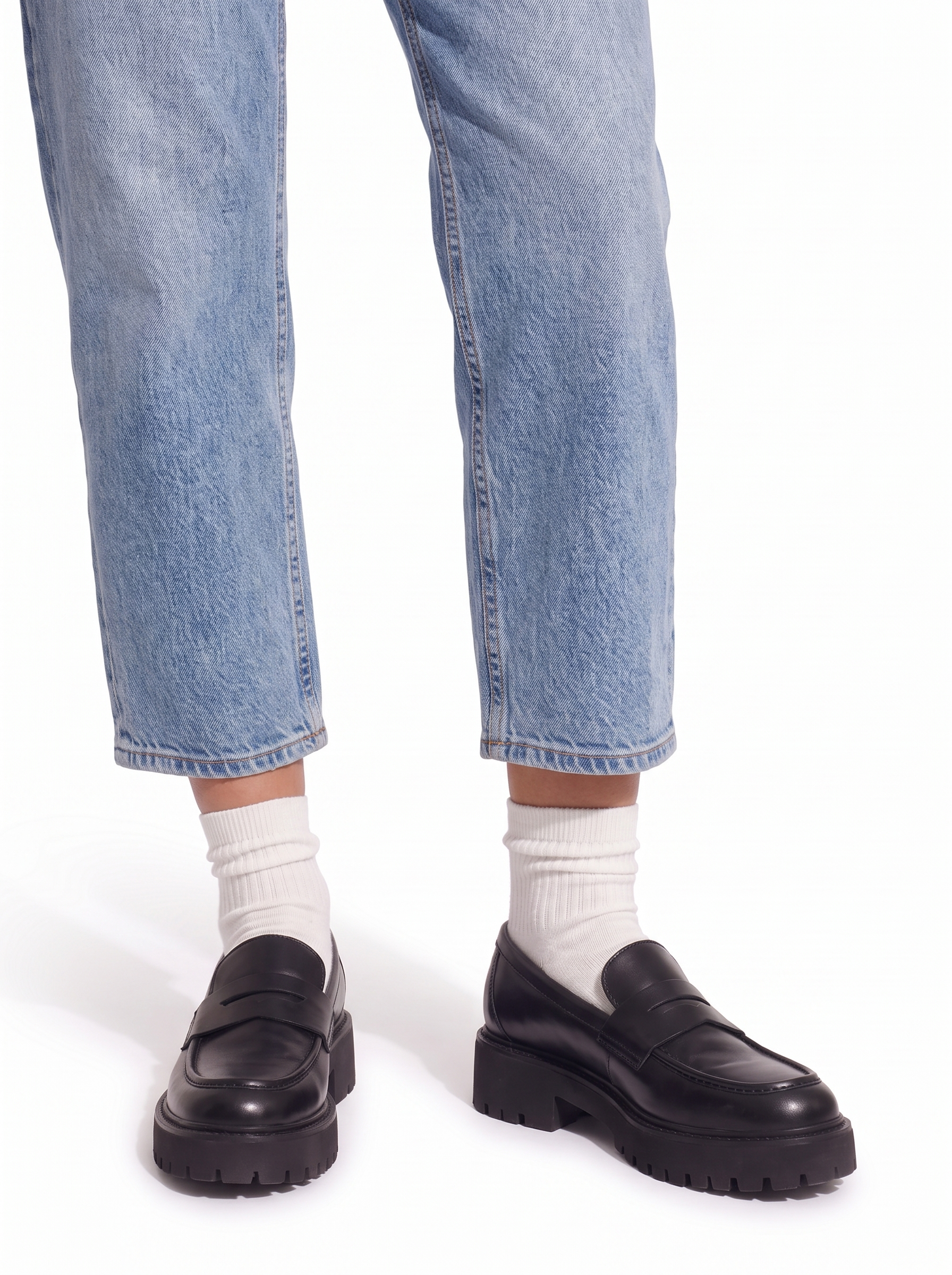 Black platform loafers styled with cropped jeans, knees down view